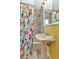 Bright bathroom with colorful shower curtain, sink and mirror, and tiled shower at 415 W Marion Ave, Punta Gorda, FL 33950