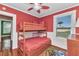 Red bedroom features a wooden bunk bed, ceiling fan, and natural light at 415 W Marion Ave, Punta Gorda, FL 33950