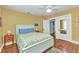 Cozy bedroom featuring hardwood floors, a ceiling fan, and an en suite bathroom at 415 W Marion Ave, Punta Gorda, FL 33950