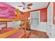 Red bedroom features a wooden bunk bed, ceiling fan, and natural light at 415 W Marion Ave, Punta Gorda, FL 33950