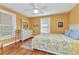 Bedroom features a white dresser, ceiling fan, and colorful accents against yellow walls at 415 W Marion Ave, Punta Gorda, FL 33950