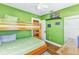 Green bedroom with wooden bunk bed, ceiling fan, and wall decorations at 415 W Marion Ave, Punta Gorda, FL 33950
