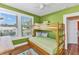 Green bedroom with wooden bunk bed, ceiling fan, and natural light from two windows at 415 W Marion Ave, Punta Gorda, FL 33950