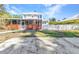 Charming home exterior showcasing a delightful screened-in porch and well-kept lawn at 415 W Marion Ave, Punta Gorda, FL 33950