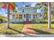 Charming two-story home with a brick walkway, lush landscaping, and inviting front porch at 415 W Marion Ave, Punta Gorda, FL 33950
