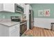Well-lit kitchen with stainless steel appliances, granite countertops, and fresh blue walls at 415 W Marion Ave, Punta Gorda, FL 33950