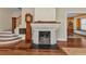 Cozy living room featuring a brick fireplace, hardwood floors, and a staircase leading to the upper level at 415 W Marion Ave, Punta Gorda, FL 33950