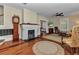 Cozy living room with hardwood floors, a painted brick fireplace, and a ceiling fan at 415 W Marion Ave, Punta Gorda, FL 33950
