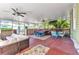 Enclosed porch with brick flooring, ceiling fans, and outdoor furniture, perfect for entertaining at 415 W Marion Ave, Punta Gorda, FL 33950