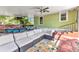 Outdoor porch with brick flooring, dining and seating area, ceiling fans, and stairs at 415 W Marion Ave, Punta Gorda, FL 33950