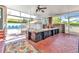 Inviting enclosed porch features brick flooring, comfortable seating, and views of the backyard pool at 415 W Marion Ave, Punta Gorda, FL 33950