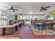 Enclosed porch with brick flooring, ceiling fans, comfortable seating, and a glimpse of backyard at 415 W Marion Ave, Punta Gorda, FL 33950