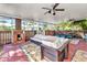 Enclosed porch with brick flooring, ceiling fans, outdoor fireplace, and comfortable seating area at 415 W Marion Ave, Punta Gorda, FL 33950
