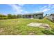 Spacious backyard with lush lawn, screened lanai, tropical foliage, and convenient fire pit, perfect for outdoor enjoyment at 457 Glenridge Nw Ave, Port Charlotte, FL 33952