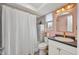 Bright bathroom with modern fixtures, a shower with white curtain, and a vanity with a dark countertop at 457 Glenridge Nw Ave, Port Charlotte, FL 33952