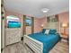 Relaxing bedroom with pink walls, light wood flooring, and a large bed with teal bedding and lots of natural light at 457 Glenridge Nw Ave, Port Charlotte, FL 33952