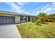 Charming single-story home featuring a well-manicured lawn and a spacious driveway leading to an attached two-car garage at 457 Glenridge Nw Ave, Port Charlotte, FL 33952