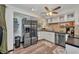 Well-equipped kitchen featuring stainless steel appliances, white cabinetry, and tile backsplash with wood-look flooring at 457 Glenridge Nw Ave, Port Charlotte, FL 33952