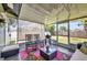 Cozy screened porch with comfortable seating, a glass table, and a view of the backyard with lush green lawn at 457 Glenridge Nw Ave, Port Charlotte, FL 33952