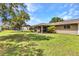 Extensive backyard features a screened patio, lush lawn, and mature trees, creating an outdoor oasis at 496 Fletcher St, Port Charlotte, FL 33954
