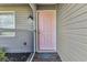 Close-up featuring a pink front door with a welcome mat, complemented by neutral siding at 496 Fletcher St, Port Charlotte, FL 33954