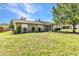Charming single-story home featuring well-kept landscaping and a cozy, inviting facade under a bright blue sky at 496 Fletcher St, Port Charlotte, FL 33954