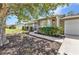 Close up showing the entrance with tidy landscaping, leading to a single story home with an attached garage at 496 Fletcher St, Port Charlotte, FL 33954