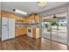 Bright kitchen featuring wooden cabinets, white appliances, and sliding glass doors to the lanai at 496 Fletcher St, Port Charlotte, FL 33954