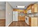 Bright kitchen with white appliances, wood cabinets and flooring at 496 Fletcher St, Port Charlotte, FL 33954