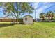 Backyard view featuring a storage shed and a chair, perfect for outdoor projects and storage at 496 Fletcher St, Port Charlotte, FL 33954