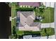 Aerial view showing the home's backyard, pool, dock, tile roof, landscaping, and proximity to the water at 531 Madrid Blvd, Punta Gorda, FL 33950
