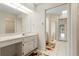 Bright bathroom featuring a vanity with ample storage, a large mirror, and access to the shower and closet at 531 Madrid Blvd, Punta Gorda, FL 33950