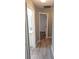Hallway showcasing wood-look flooring, leading to a bathroom and bedroom at 6341 Opa Locka Ln, North Port, FL 34291