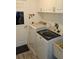 Convenient laundry room featuring modern washer and dryer, white cabinets, and door to outside at 6341 Opa Locka Ln, North Port, FL 34291