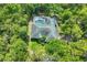 Home with a screened-in pool and a lush green yard, surrounded by mature trees and vibrant foliage at 6514 N Biscayne Dr, North Port, FL 34291