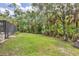 Expansive grassy backyard with mature trees and lush landscaping, offering privacy and a serene outdoor space at 6514 N Biscayne Dr, North Port, FL 34291