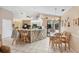 Open kitchen with island, breakfast bar, stainless appliances, and dining area at 6514 N Biscayne Dr, North Port, FL 34291