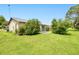 Spacious backyard with a concrete patio, lawn, and some mature trees at 6540 Kenwood Dr, North Port, FL 34287