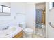 Well-lit bathroom featuring a sink, toilet, and shower with blue patterned curtains at 6540 Kenwood Dr, North Port, FL 34287