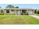 Charming single-story home with a well-manicured front yard and attached garage at 6540 Kenwood Dr, North Port, FL 34287