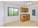 Efficient kitchen space with plenty of wood cabinets, a sink, a window, and convenient access to the outdoors at 6540 Kenwood Dr, North Port, FL 34287