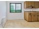 Practical kitchen area with wood cabinets, a sink, and a large window providing natural light and a view of the outdoors at 6540 Kenwood Dr, North Port, FL 34287