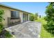 Concrete patio in the backyard with a sliding glass door entrance and mature trees at 6540 Kenwood Dr, North Port, FL 34287