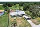 Aerial view of a cozy home with a metal roof, long driveway and private pool surrounded by lush greenery at 8513 Heister St, Punta Gorda, FL 33982