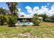 Spacious backyard with an in-ground pool, mature palm trees, and well-maintained lawn, ideal for outdoor enjoyment at 8513 Heister St, Punta Gorda, FL 33982