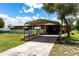 Wide view of the carport with a long driveway leading up to a charming single story home at 8513 Heister St, Punta Gorda, FL 33982