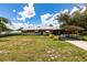 Charming single-story home with a metal roof, carport, and a well-maintained front yard under a sunny sky at 8513 Heister St, Punta Gorda, FL 33982