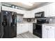 Modern kitchen featuring black appliances, bright white cabinetry, and a decorative tile backsplash at 8513 Heister St, Punta Gorda, FL 33982