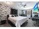 Spacious main bedroom with a brick accent wall, comfortable bed, and a ceiling fan at 8513 Heister St, Punta Gorda, FL 33982