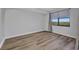 Simple bedroom with wood-look flooring and a window bringing in natural light at 900 E Marion Ave # 1203, Punta Gorda, FL 33950